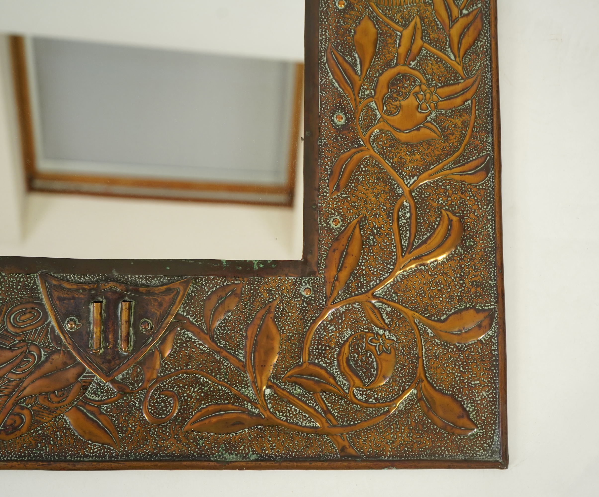An Arts and Crafts embossed copper mirror, manner of Talwin Morris, Glasgow School